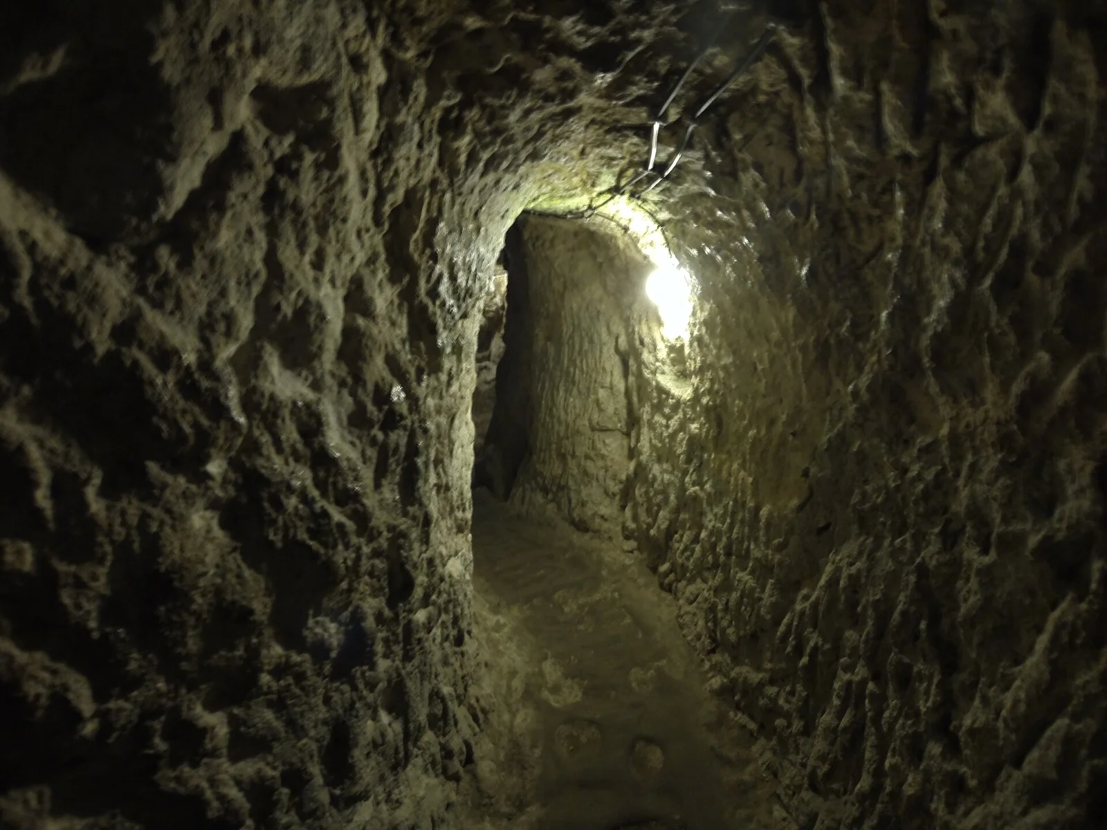 Narrow Derinkuyu passage with visible modern visitor lighting
