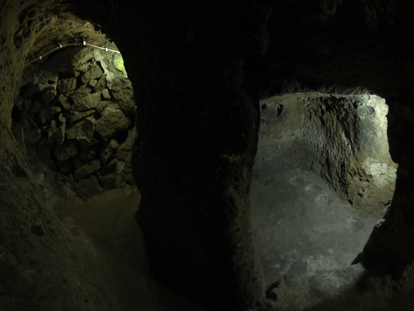 A round stone barrier beside a rock-cut opening at Derinkuyu