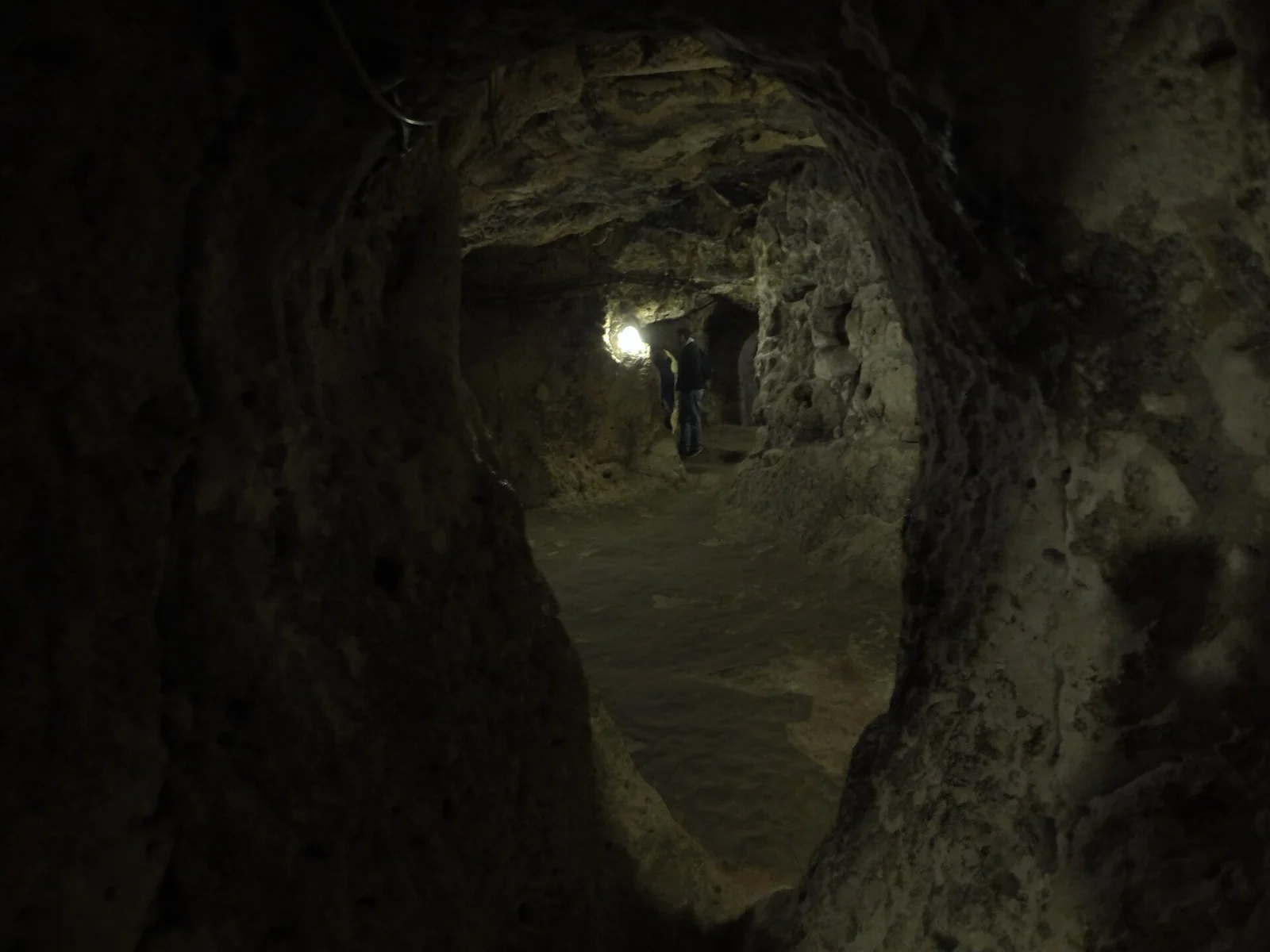 A narrow rock-cut passage inside Derinkuyu with a modern light