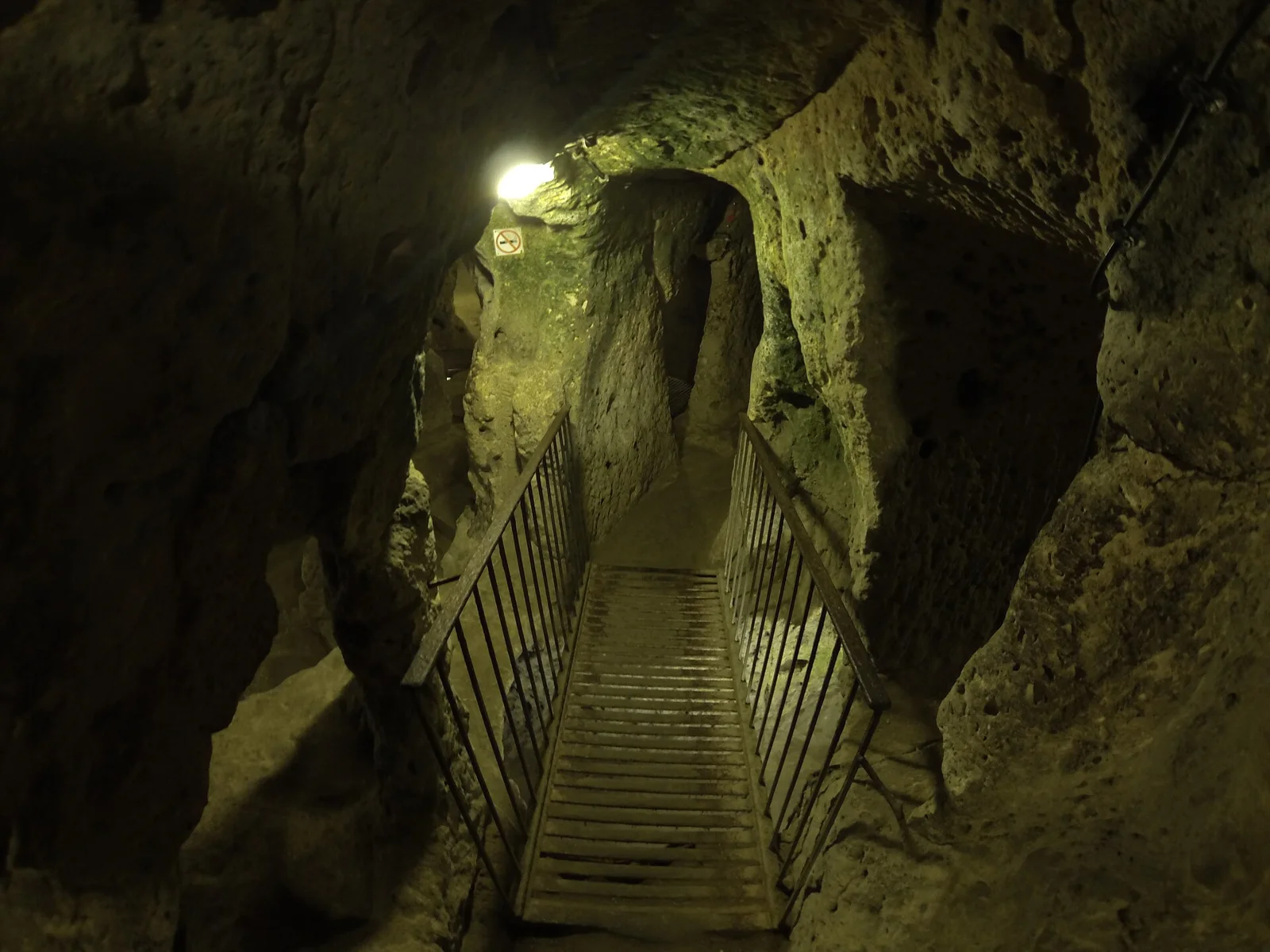 A handrail and stairs in a narrow passage at Derinkuyu