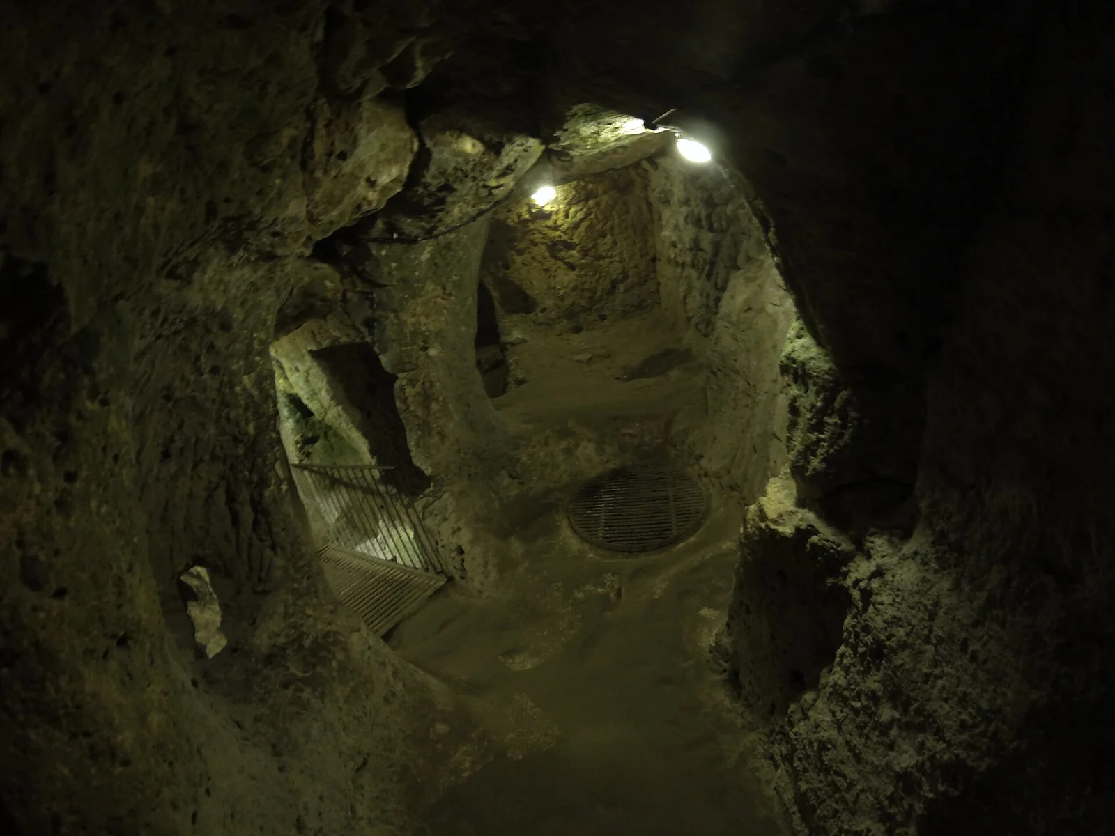 An illuminated rock-cut room with a narrow doorway in Derinkuyu